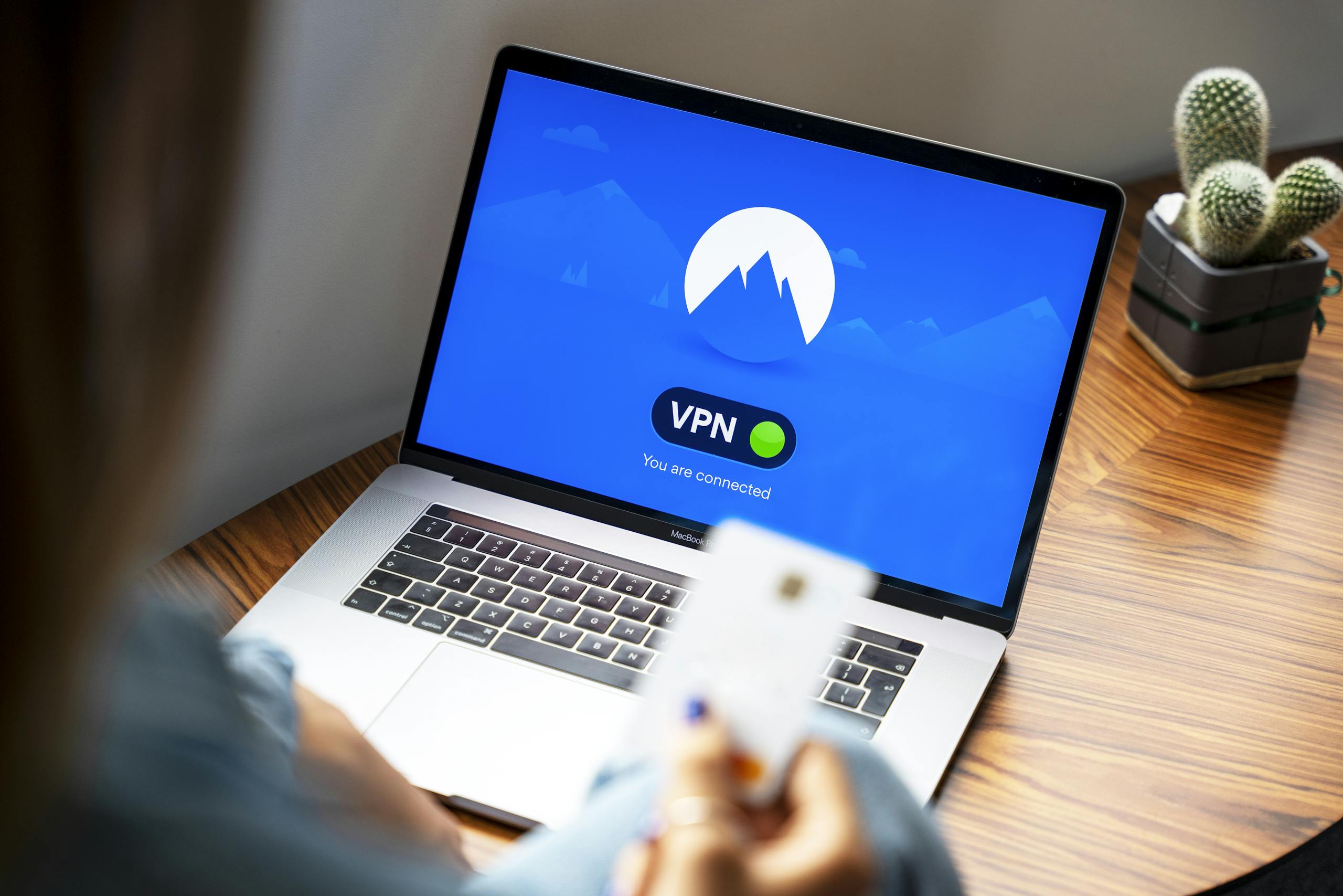 A person using a VPN on a laptop, symbolizing secure internet browsing in a modern indoor setting.